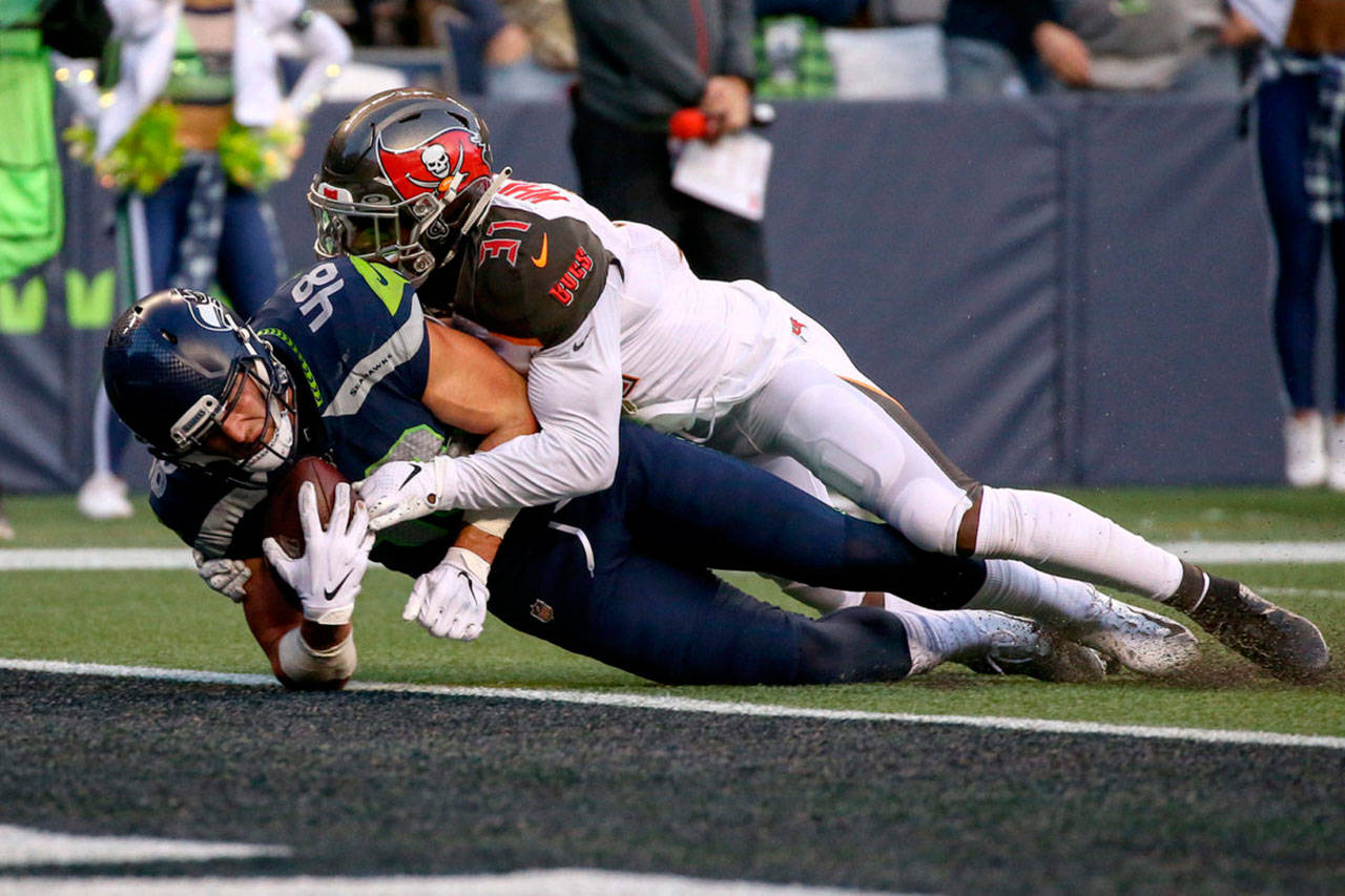 Seahawks Jacob Hollister falls across the goal line for the game winning touchdown against Buccaneers Jordan Whitehead in overtime Sunday afternoon at CenturyLink Field in Seattle on November 3, 2019.(Kevin Clark | The Herald)