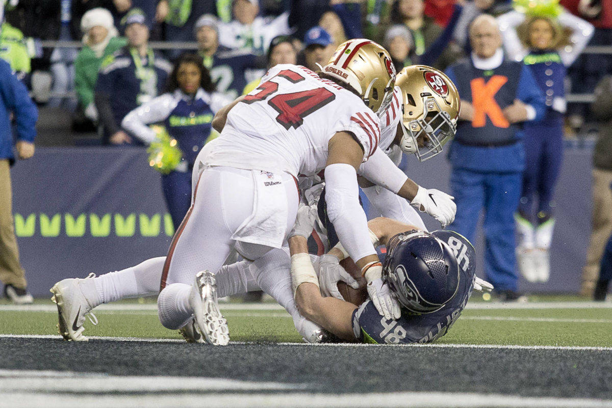 Seattle Seahawks’ Jacob Hollister is stopped inches from the goal line by San Francisco’s Fred Warner Sunday evening at CenturyLink Field in Seattle on December 29, 2019. The 49ers won 26-21. (Kevin Clark / The Herald)