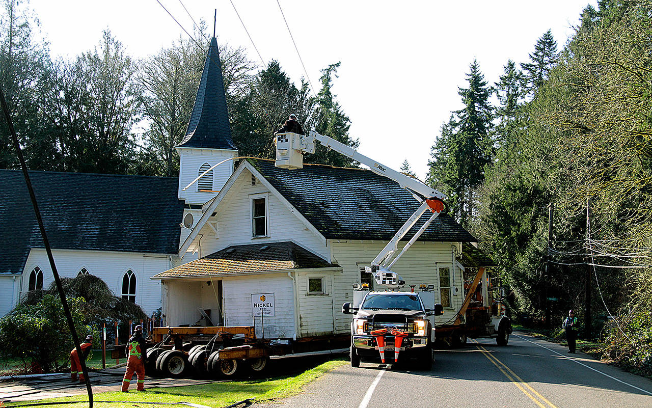 The 100-year-old parsonage home next to Port Madison Lutheran Church is moved off its lot Wednesday morning. (Brian Kelly | Bainbridge Island Review)