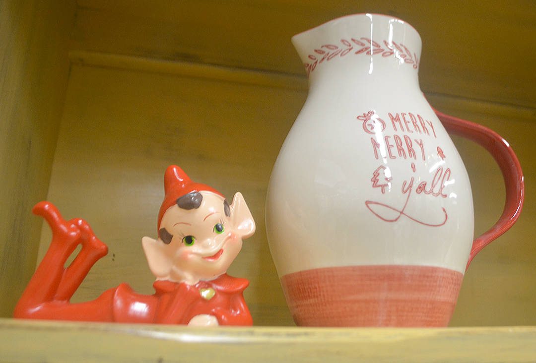 A cute elf on the shelf and pitcher.