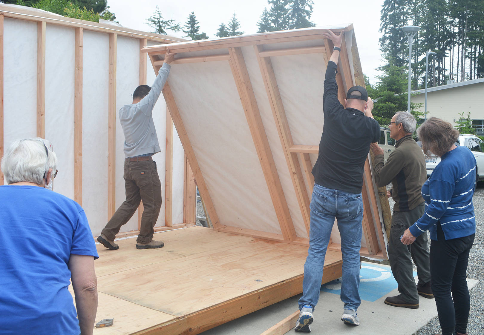 Volunteers put up one side of the tiny house.