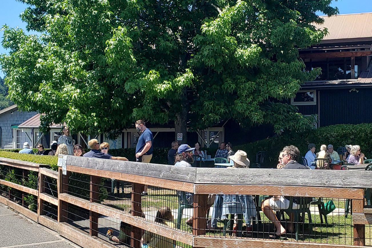A Pride flag hangs at Cafe Hitchock in honor of Pride Month.
Folks enjoy the summer weather at Doc’s Marina Grill in Winslow.