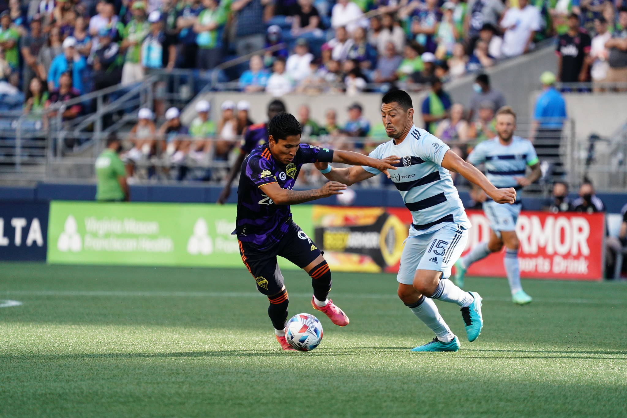 Raul Ruidiaz tries to squeeze by a Sporting KC defender in Seattle’s 3-1 loss on Sunday at Lummen Field. (Mike Fiechtner/Sounders FC Communications)