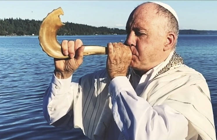 Rabbi Dario Feiguin blows into a shofar, an ancient musical horn typically made of a ram’s horn.