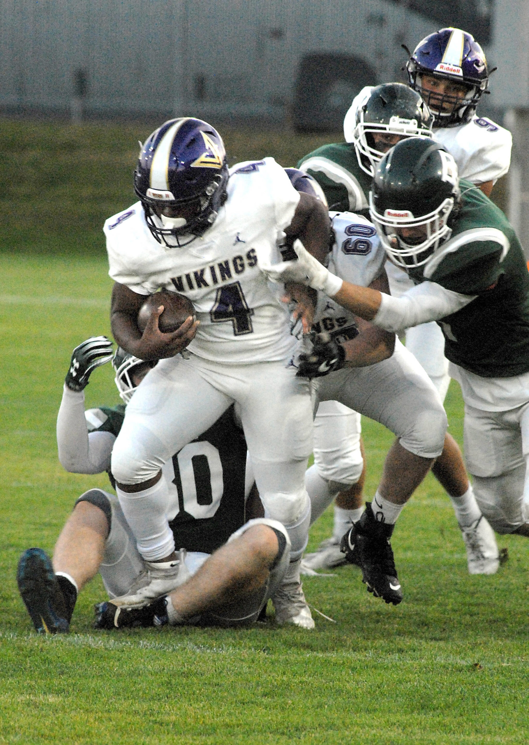 North Kitsap’s Zeke Harris, front, gets an assist from teammate Lincoln Hawkins before being wrapped up by the Port Angeles defense on Friday night at Port Angeles Civic Field. (Keith Thorpe/Peninsula Daily News)
