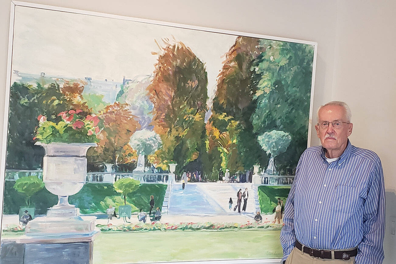 Eldon Van Liere stands next to his late wife's painting of Luxembourg Gardens in Paris, where they often traveled together. Tyler Shuey/Bainbridge Island Review