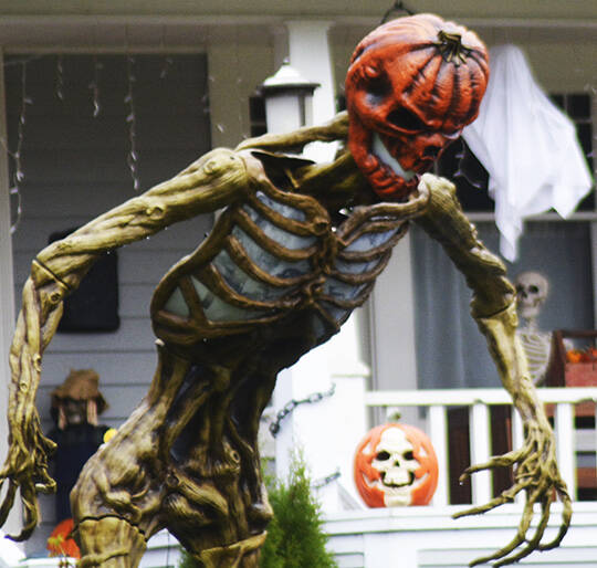 Trick-or-treaters are going to have to muster up some bravery to try to get away with any treats from this house with this scary, giant, pumpkin-headed skeleton providing protecting.