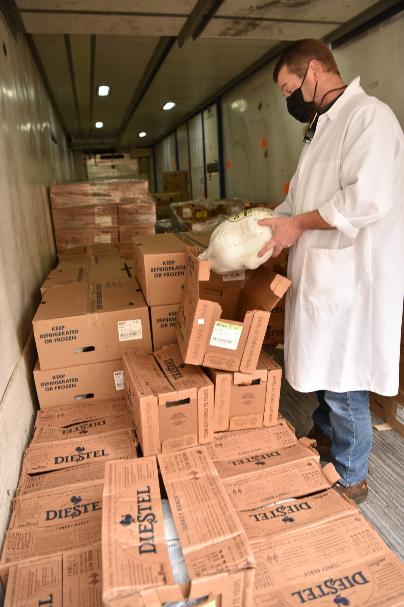 Town & Country meat department manager Tony Lane unboxes a frozen turkey in the "turkey truck" where some of the 1,071 whole turkeys and 324 turkey breasts were stored for Thanksgiving shoppers.