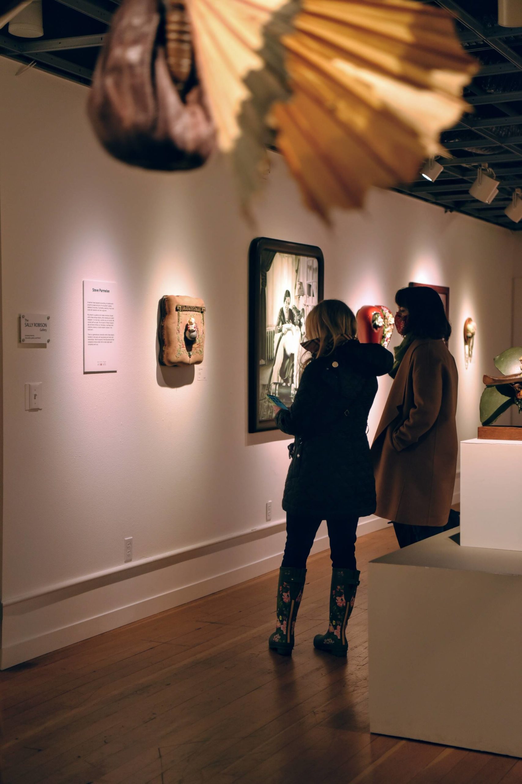 Two visitors viewing the Bygones art exhibition of paintings by Julie Read and assemblage by Steve Parmelee at the Bainbridge Arts and Crafts gallery at 151 Winslow Way E. Nancy Treder/Bainbridge Island Review photos