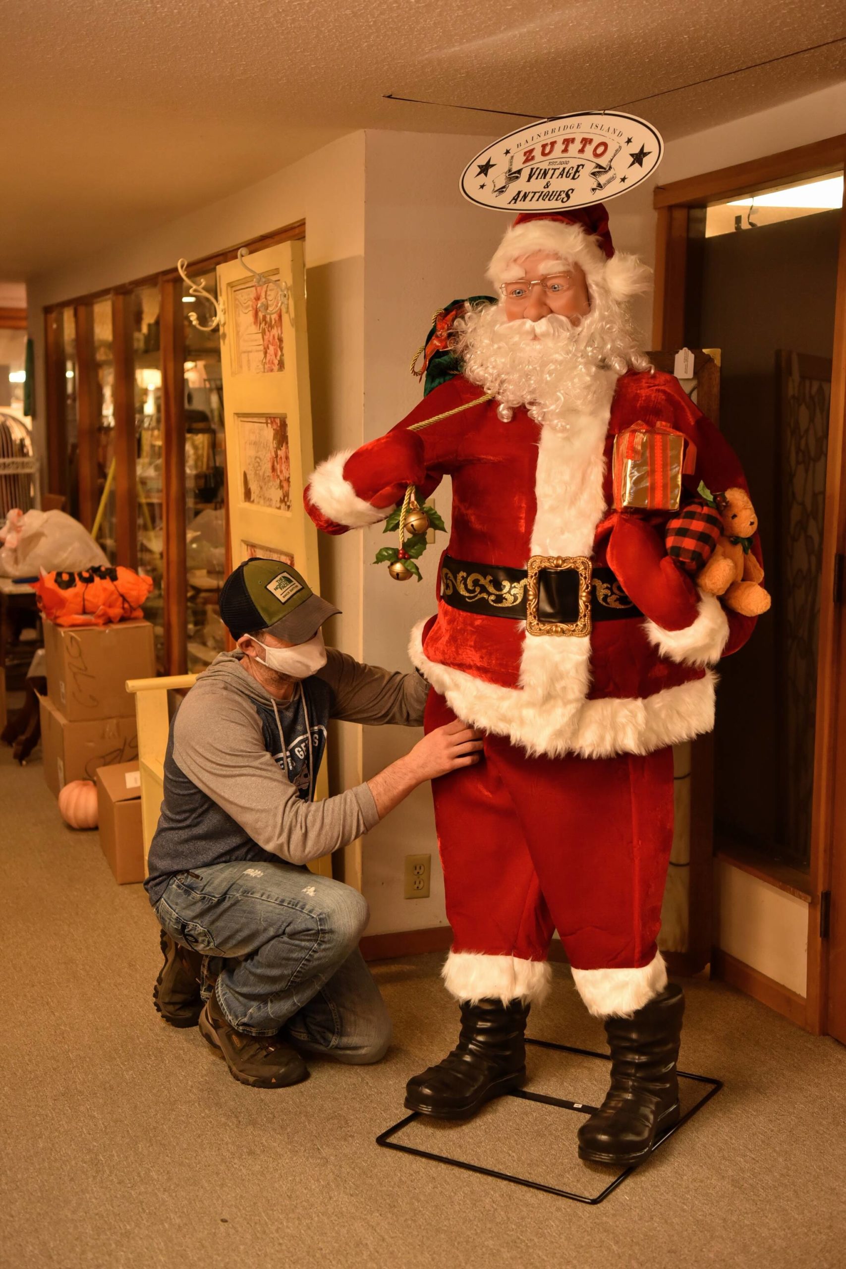 Zev Whitehead, co-owner of Zutto Vintage & Antiques located at 164 Bjune Dr SE in Winslow, readies a motion-controlled Santa to greet visitors at the store entrance.