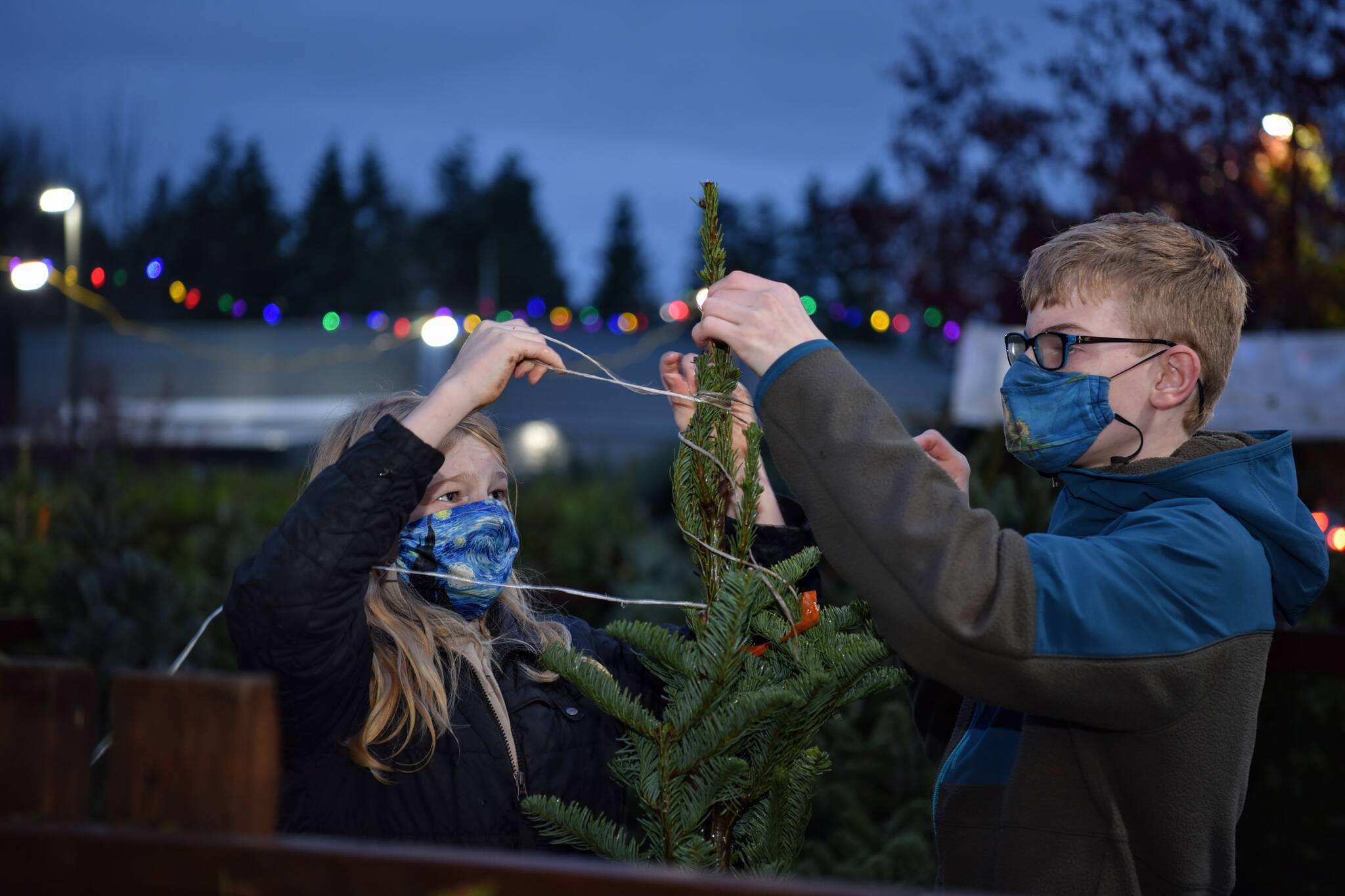 Scouts Adrian Meidell and Nathan Cole untie trees for customers at the Boy Scout Christmas Tree lot on High School Road.