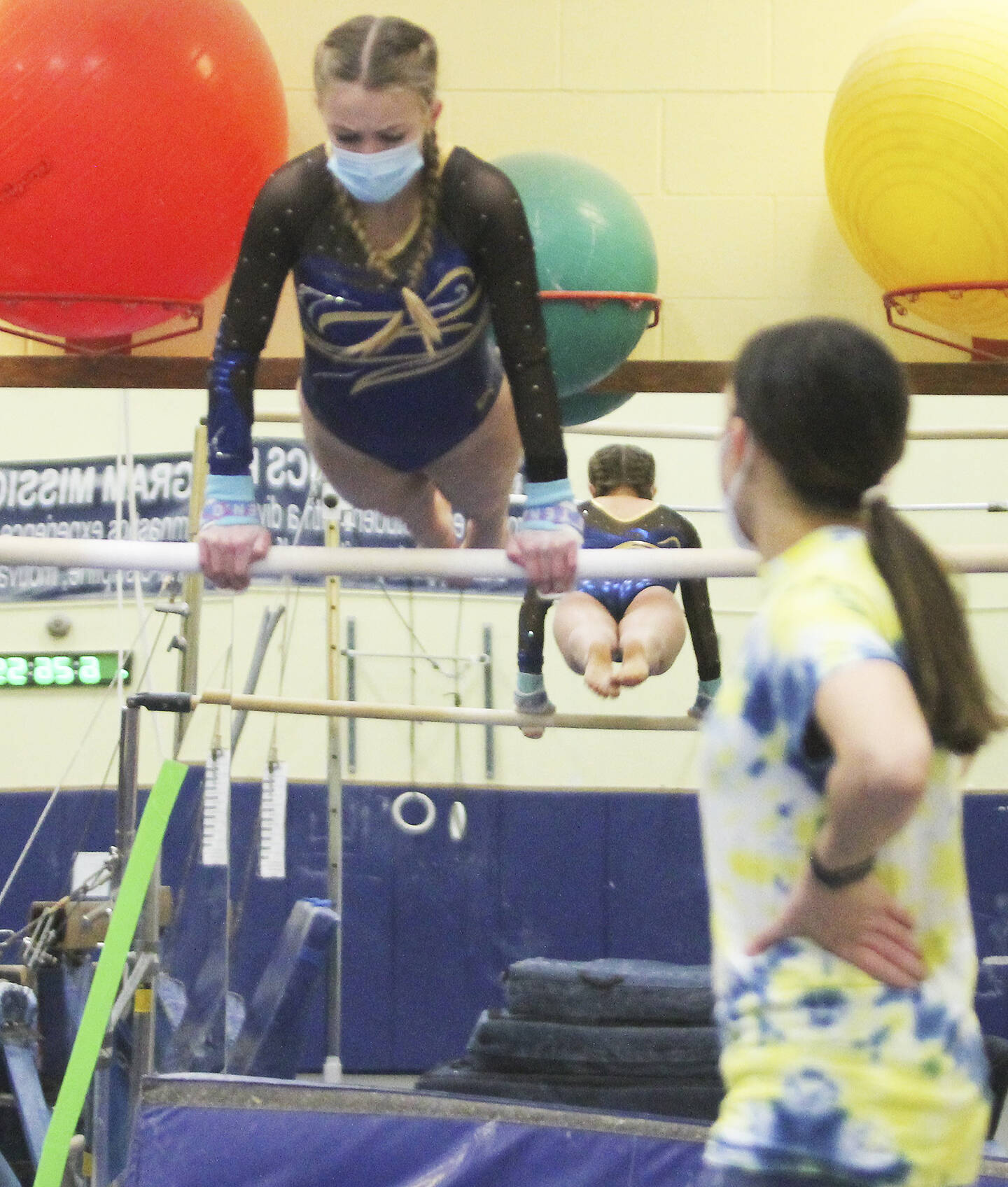 Bainbridge coach Katie Rochon watches as Avery Gray does her routine on the uneven parallel bars, which she won.
