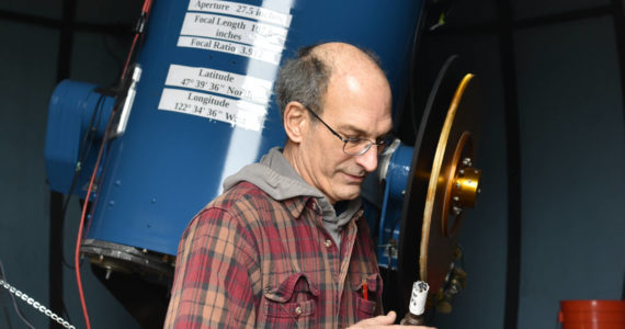 Frank Petrie, Battle Point Observatory Association president, adjusts the telescope alignment.
