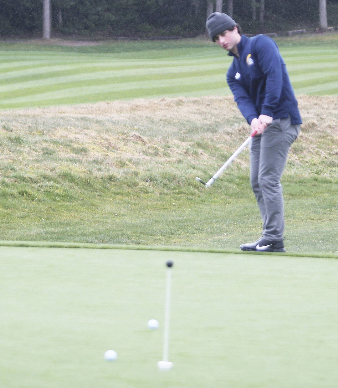 Bainbridge’s Justin Marten practices chipping prior to the match against Kingston.