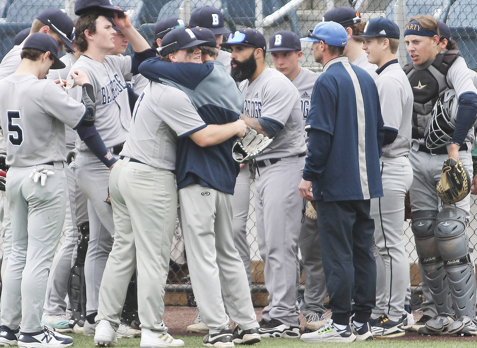 Joey Hildebrandt, center, gets a hug from a coach after hitting a key double in the contest.