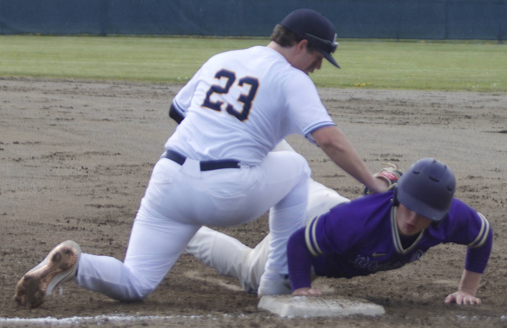 Colton Bower of NK dives safely back to first base after hitting a single in the first inning. Zach Duffy of BHS applies the tag. Steve Powell/North Kitsap Herald