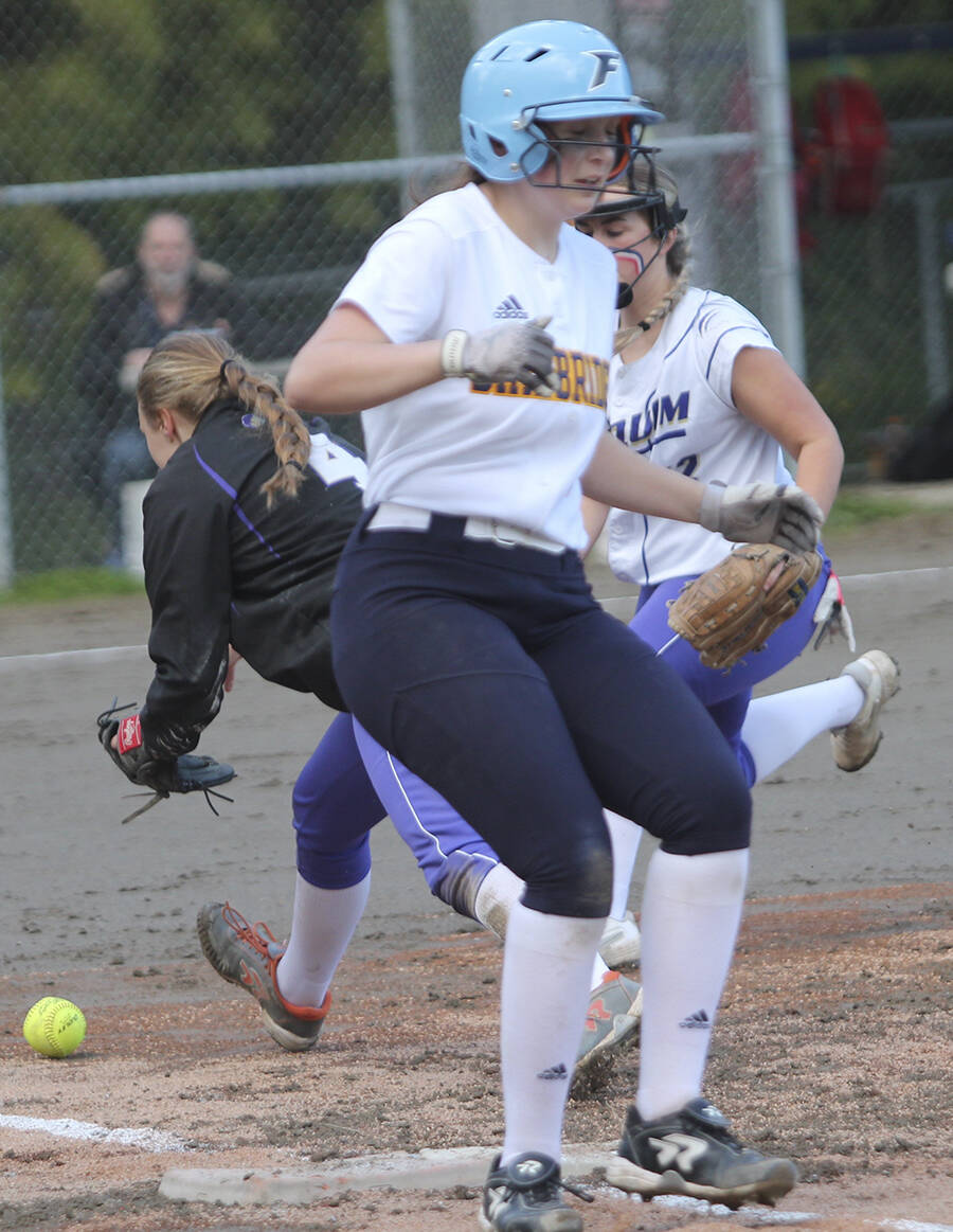 Sequim players scurry after the ball as Spartan Sophia Hoff is safe at first.