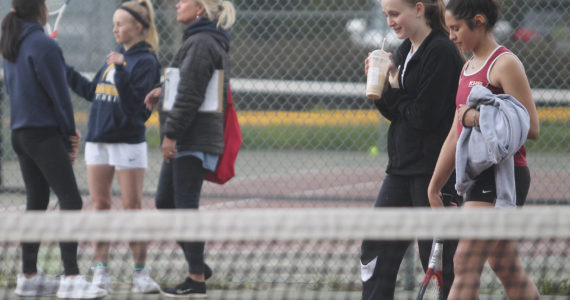 As Kingston’s No. 1 doubles team of Kylie Sandstrom and Taliya Caldara cross the court, the Bainbridge team of Aya Gatto and Kristina talk with coach Mary McCombs. Steve Powell/Bainbridge Island Review photos