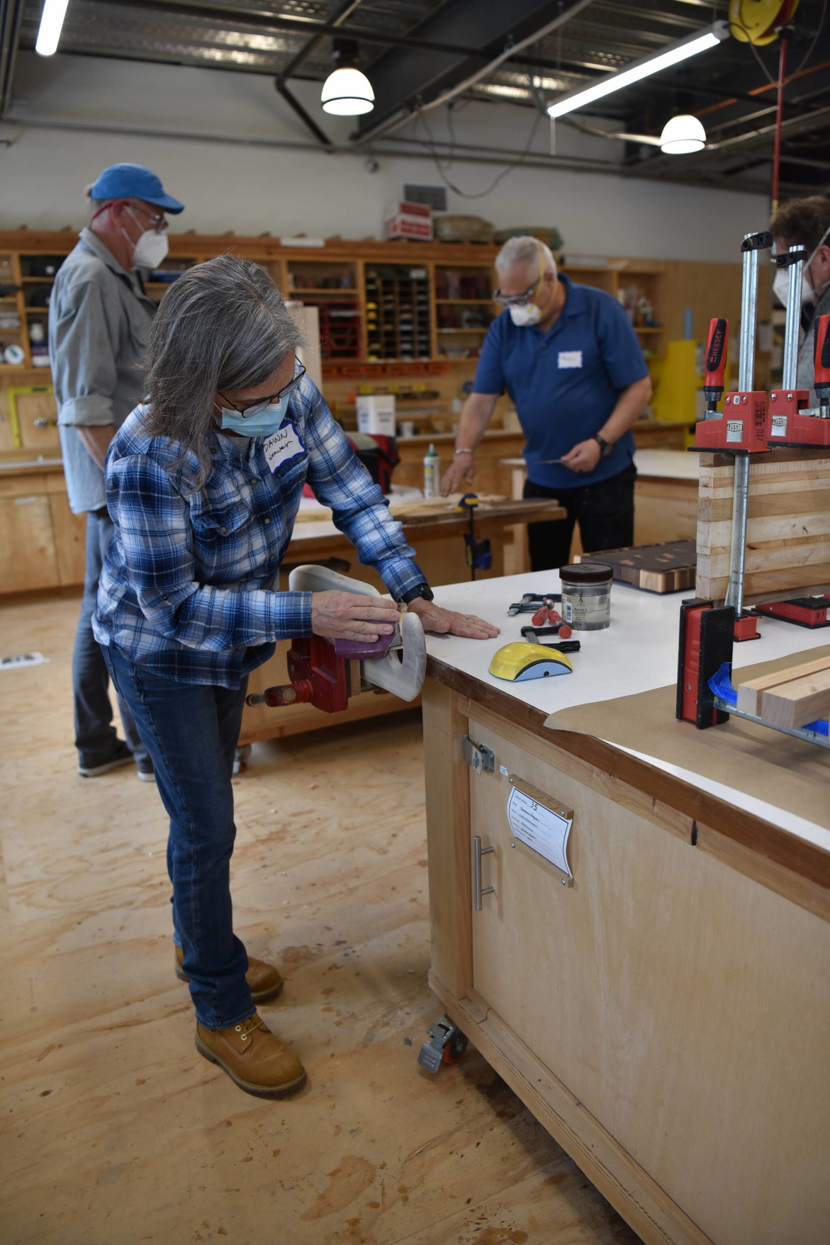 Dawn Weaver sands a cutting board in the woodworking studio.