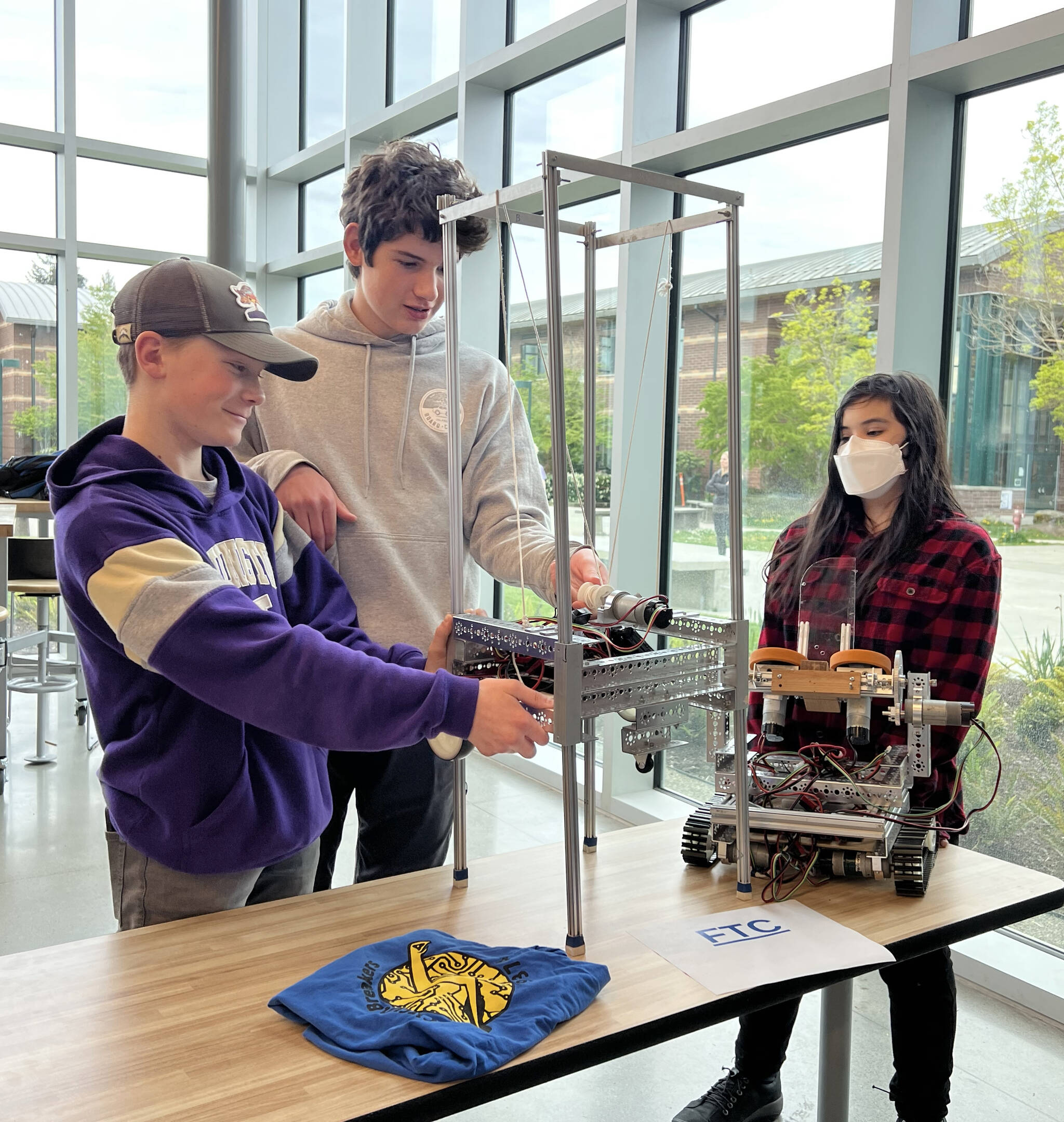 Middle school students from the Odyssey FTC team show off two robots they have engineered.