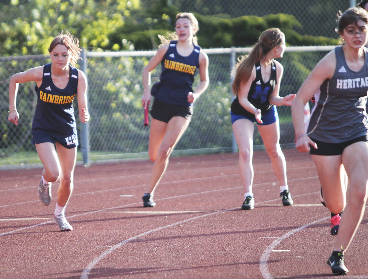 Spartan Claire Hungerford takes off as teammate Clara Maclise races to pass the baton to her on the 4 by 100 relay.