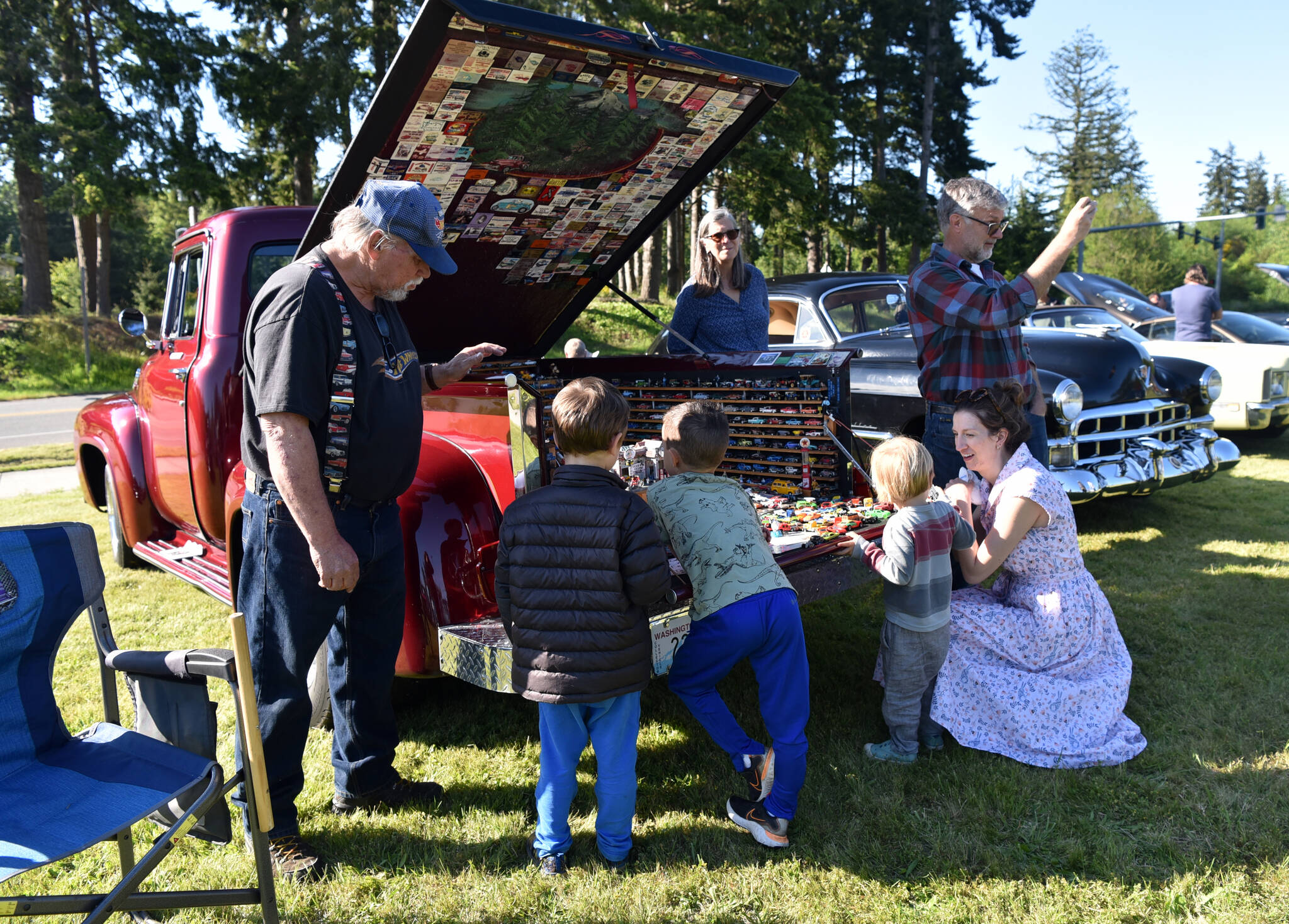 Reid Cunningham and Holden Heatherington, along with Thomas Magin and his mother, Alison Brock, look at a display of toy cars at the show.