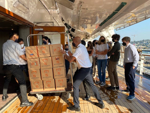 Holland America Cruise Line employees prepare a shipment of 400 books from Odyssey Middle School seventh- and eighth-graders. Courtesy Photo