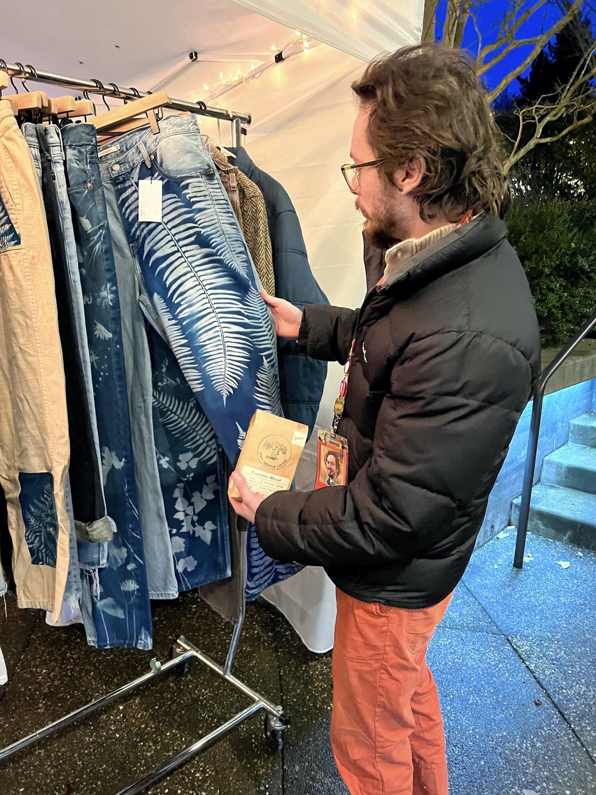 Aidan Terry admires a pair of cyan print pants at the Terra Prints booth.