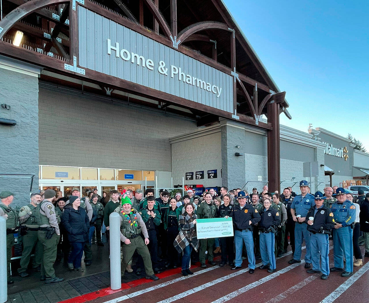 Law enforcement and youth outisde the Poulsbo Walmart Dec. 3 with the $1,500 check.