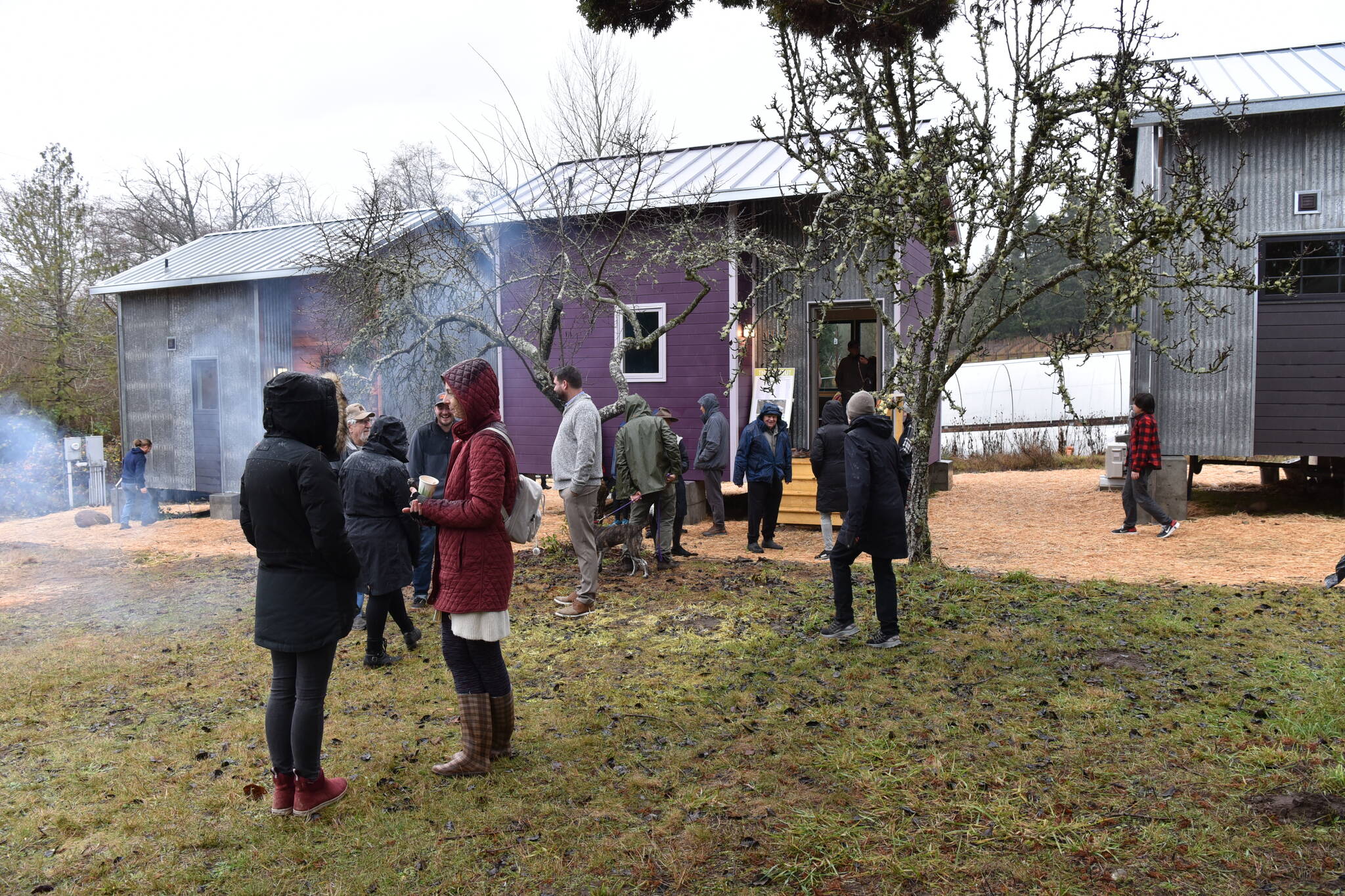 Volunteers and partners visit the Morales Farm to view the tiny homes that the community of Bainbridge Island built.