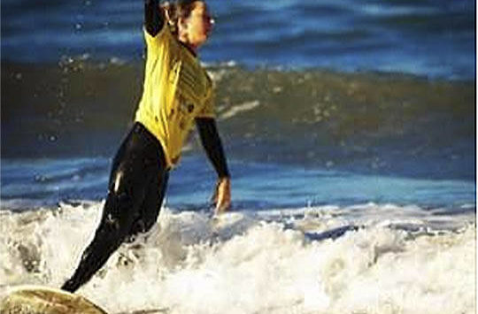 Sarah Dean of Bainbridge has been an avid surfer before and after her accident and amputation. Photos courtesy of Sarah Dean