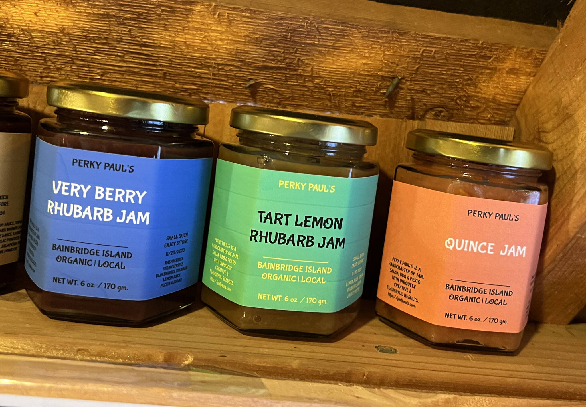 A variety of jams on a shelf.