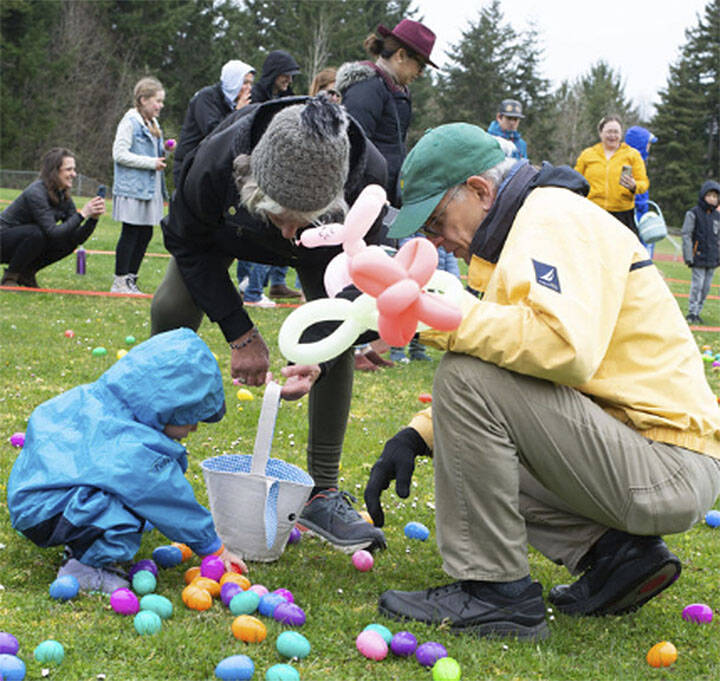 This young man gets help from a balloon-carrying adult at the egg hunt.