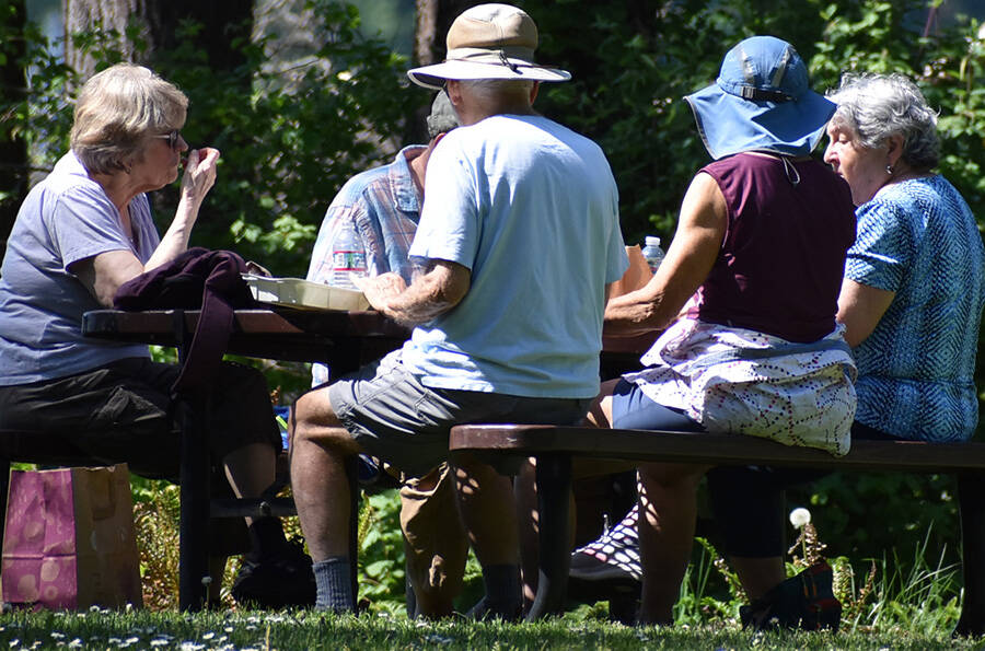 A small group gathers for a discussion at a picnic table in the morning before it got too hot.
