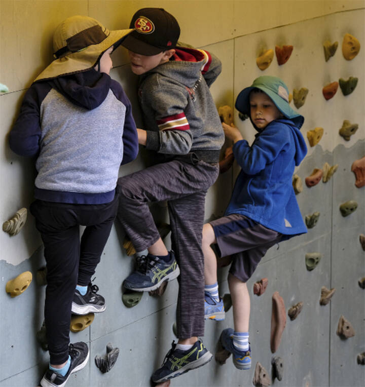 Youngsters hang out on a climbing wall.
