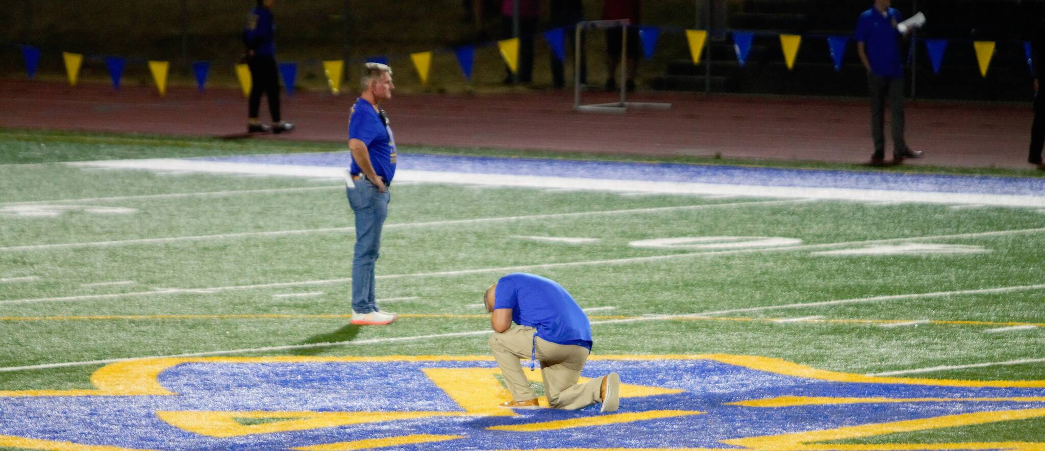 Bremerton High School assistant football coach Joe Kennedy prays alone at the 50-yard line, something he’s fought to do again as a coach for eight years.