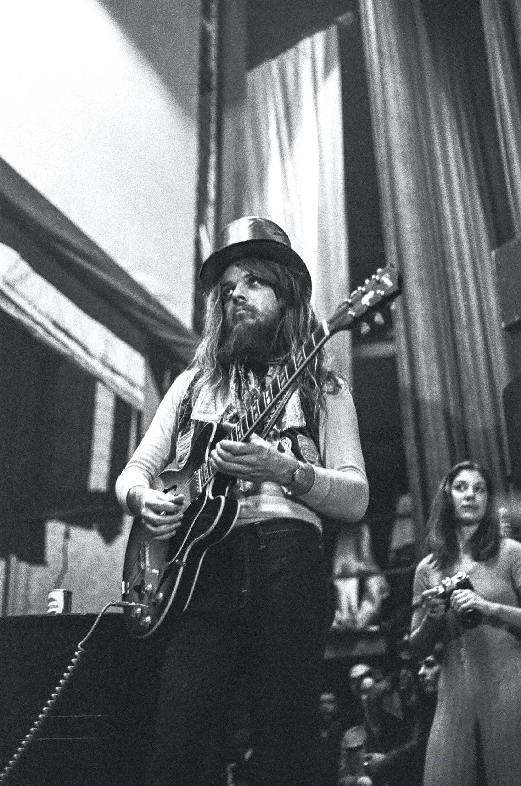 Leon Russell playing guitar as Linda Wolf looks on.