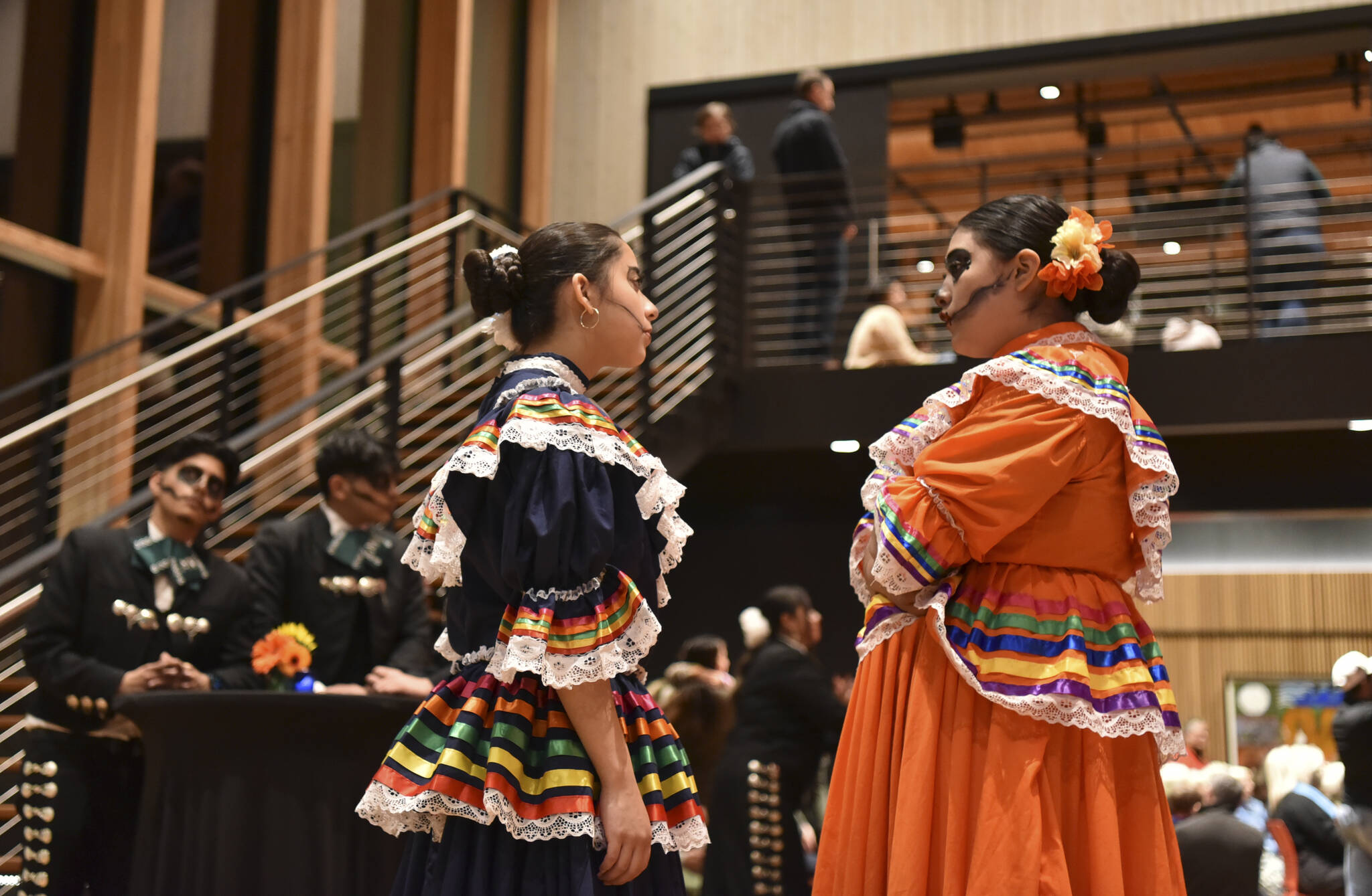 Two Mount Vernon High School Folklorico dancers wait to speak with attendees after the concert.