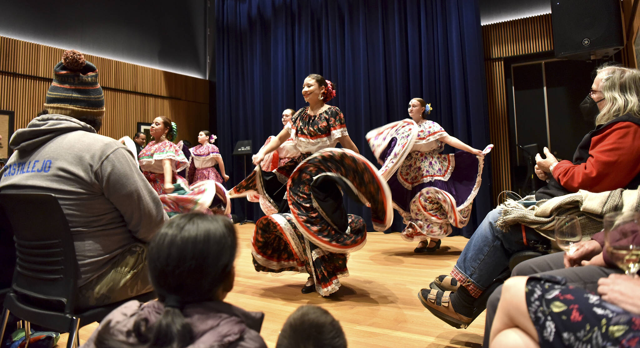 Folklorico dancers twirl in colorful dresses.
