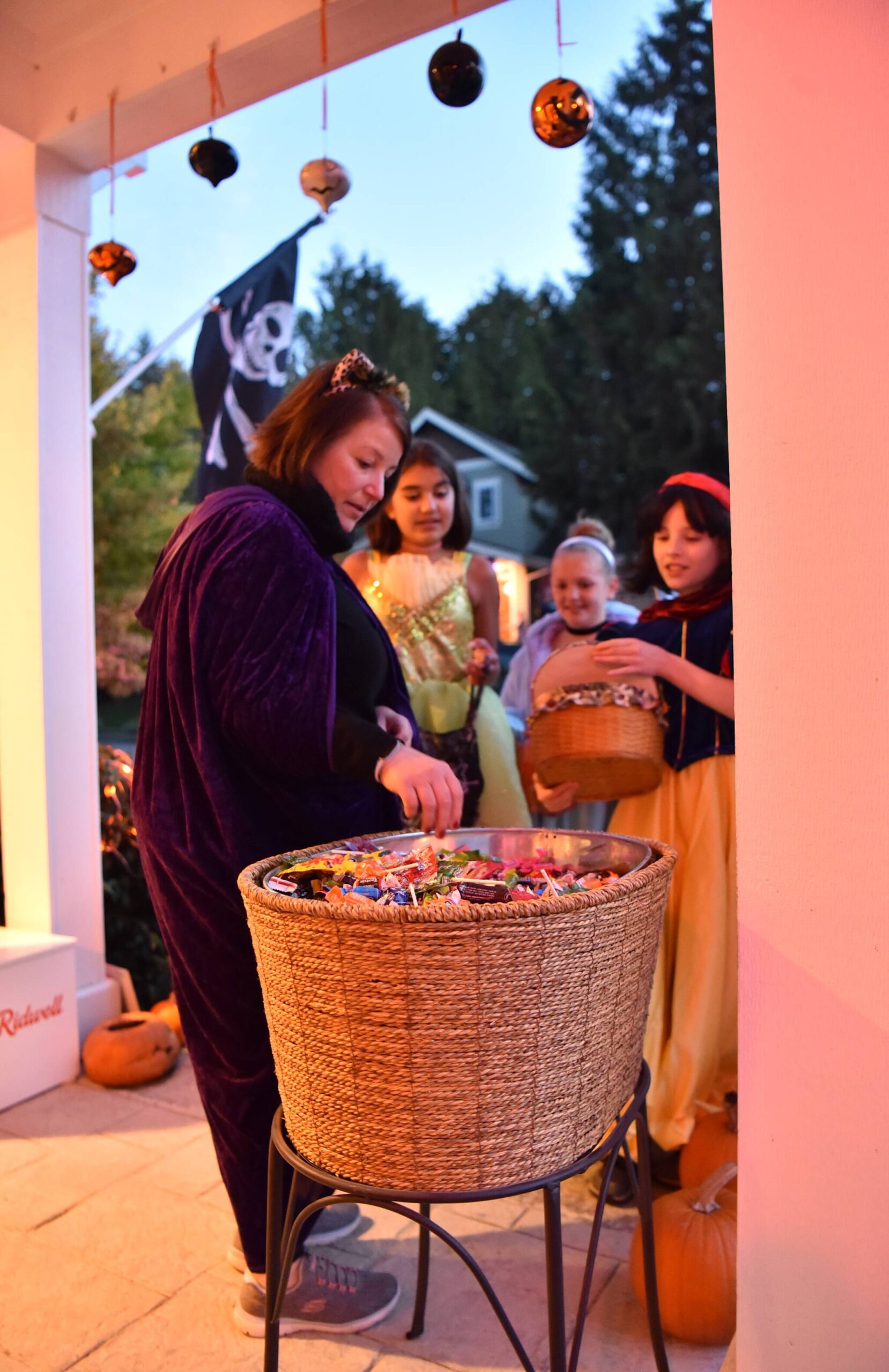 Terri Beckett gives candy to eager trick-or-treaters at her home in Northtown Woods.
