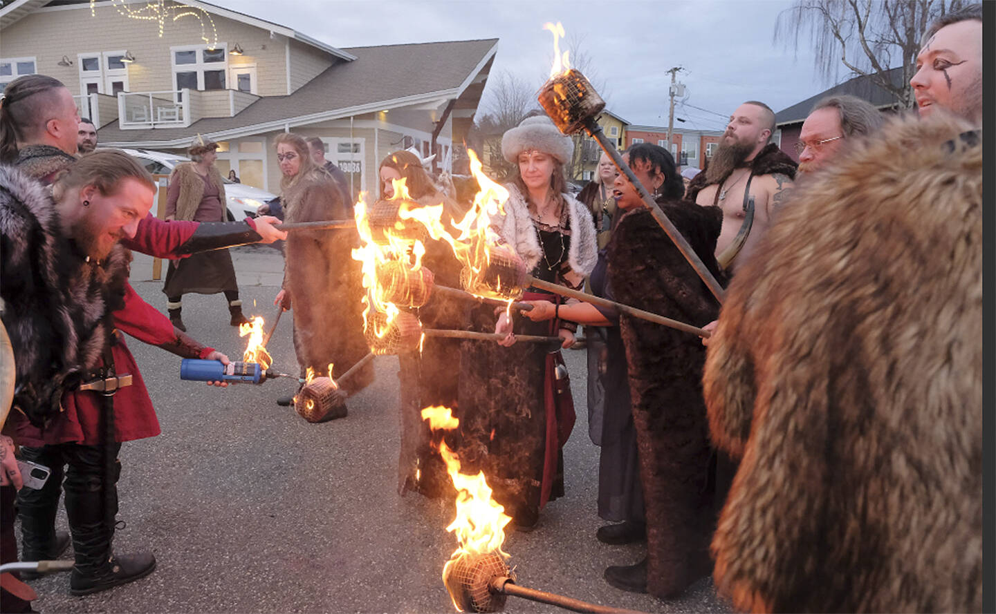 Sons of Norway Vikings light their torches and get set to march through downtown Poulsbo on their way to the waterfront to light the bonfire.