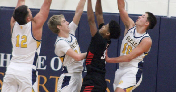 Luke Caputo/Kitsap News Group photos
Spartan Ryan Rohrbacher blocks a Palm Springs player’s shot with Will Rohrbacher and Lane McFadden defending in a 64-58 Bainbridge home win against Palm Springs Dec. 3.
