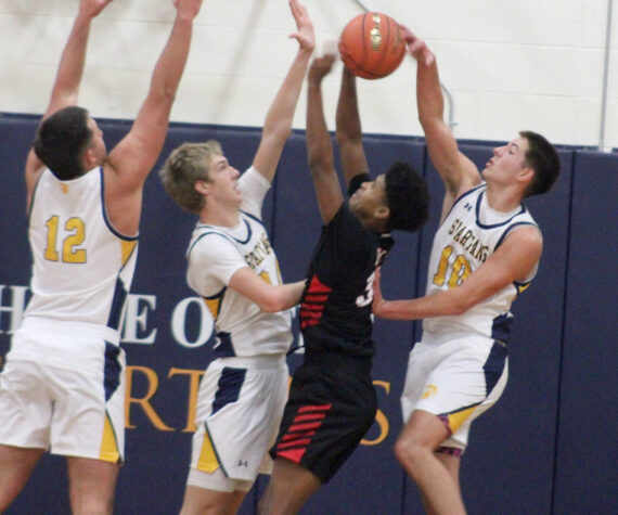 <p>Luke Caputo/Kitsap News Group photos</p>
                                <p>Spartan Ryan Rohrbacher blocks a Palm Springs player’s shot with Will Rohrbacher and Lane McFadden defending in a 64-58 Bainbridge home win against Palm Springs Dec. 3.</p>