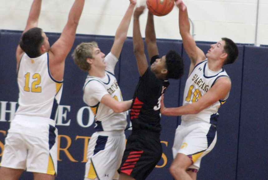 <p>Luke Caputo/Kitsap News Group photos</p>
                                <p>Spartan Ryan Rohrbacher blocks a Palm Springs player’s shot with Will Rohrbacher and Lane McFadden defending in a 64-58 Bainbridge home win against Palm Springs Dec. 3.</p>