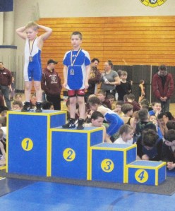 Henry Moreshead takes to the medal stand after winning second place in his weight class at the Eric White League Wrestling Tournament.