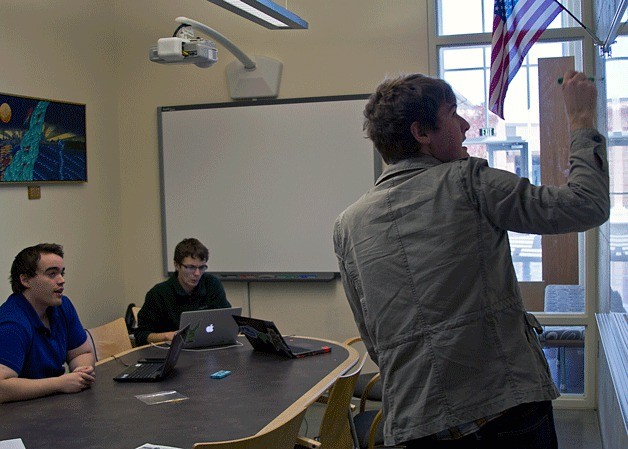 BHS debate team co-captain James Maltman (standing) outlines the key points of the new resolution being prepared for an upcoming debate to the team’s head coach Jordan Hudgens (seated on left) and co-captain Jacob Reiter (seated on right).