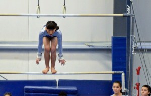 Cate Shelton-Jenck focuses on her jump to the high bar.