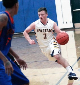 Bainbridge Spartan junior guard Trent Schulte runs the ball into the defensive efforts of the visiting Rainier Beach Vikings Friday