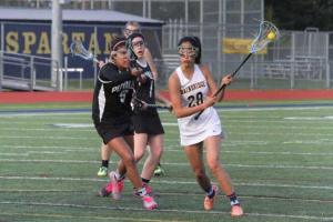 The Spartans’ Robin Hilderman attacks the net for one of her two goals against Puyallup in girls varsity lacrosse.