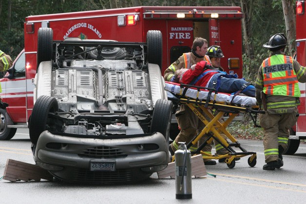 A driver involved in a two-car crash on Highway 305 in Winslow Tuesday is taken away on a gurney by emergency responders.